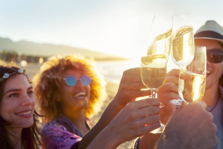 friends drinking wine on beach