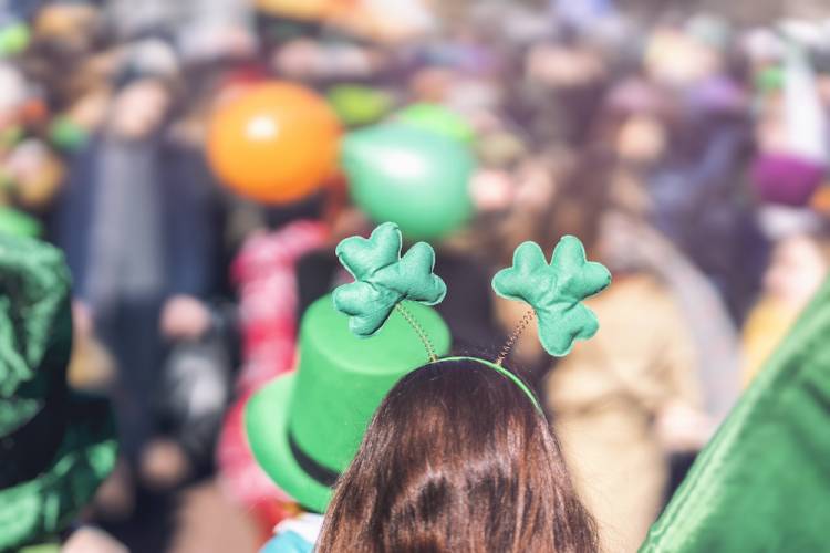 Girl with back turned toward camera is watching a St. Patrick's Day parade